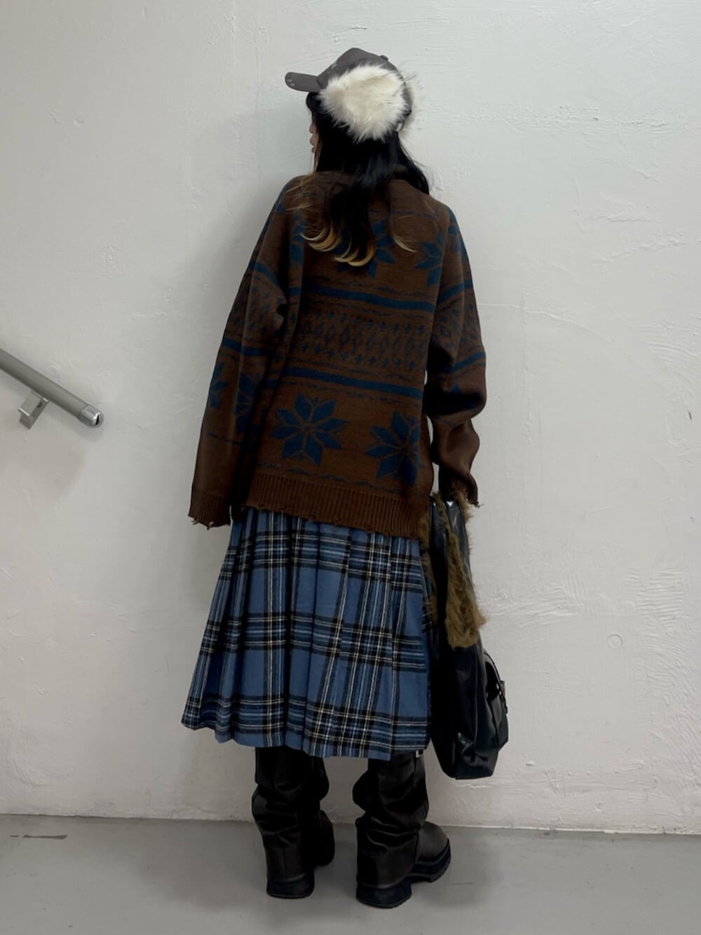 ブラック系のブーツ、レッド系のスカート、ブラウン系のカーディガン/ボレロを着用したレディースの秋コーディネートの3枚目の写真