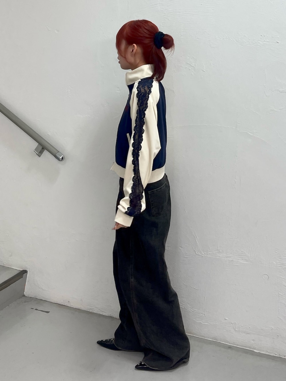 ブラック系のデニムパンツ、ブラック系のパンプス、ブルー系のジャージを着用したレディースの春コーディネートの3枚目の写真