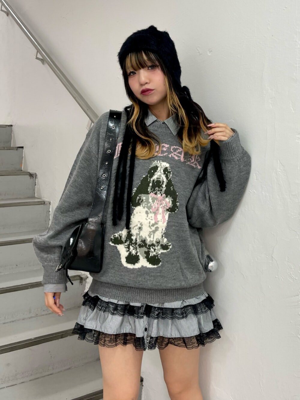 グレー系のニット/セーター、ブラック系のシャツ/ブラウス、ブラック系のブーツを着用したレディースの秋コーディネートの4枚目の写真