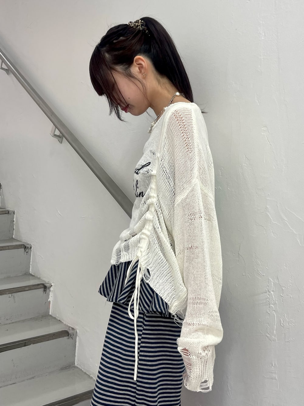 ホワイト系のニット/セーター、ブルー系のスウェットパンツ、ブラック系のパンプスを着用したレディースの春コーディネートの6枚目の写真