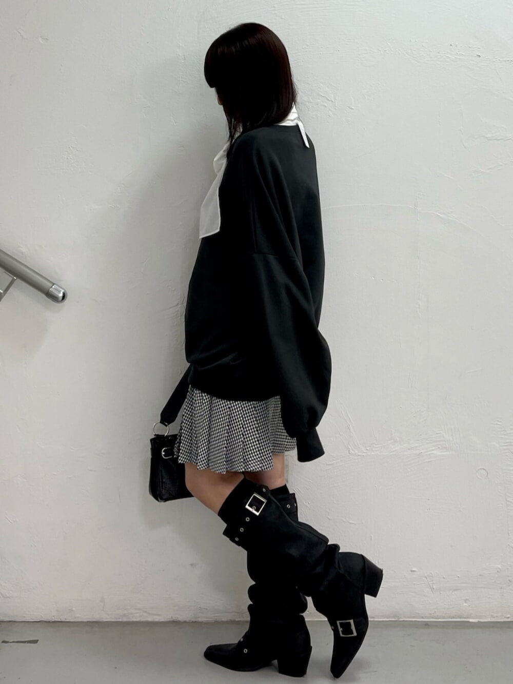 ブラック系のハンドバッグ、ブラック系のブーツ、ホワイト系のシャツ/ブラウスを着用したレディースの冬コーディネートの3枚目の写真