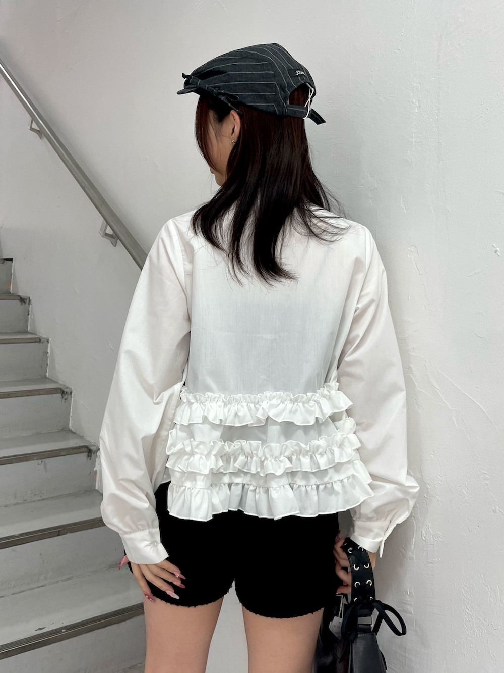 ホワイト系のシャツ/ブラウス、ブラック系のハンドバッグ、ブラック系のブーツを着用したレディースの冬コーディネートの7枚目の写真