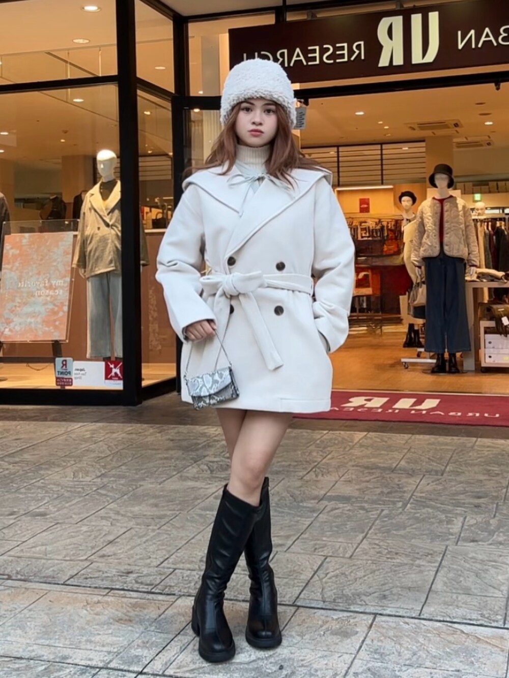 ホワイト系のニット/セーター、ブラック系のブーツ、その他のショルダーバッグを着用したレディースの秋コーディネートの3枚目の写真