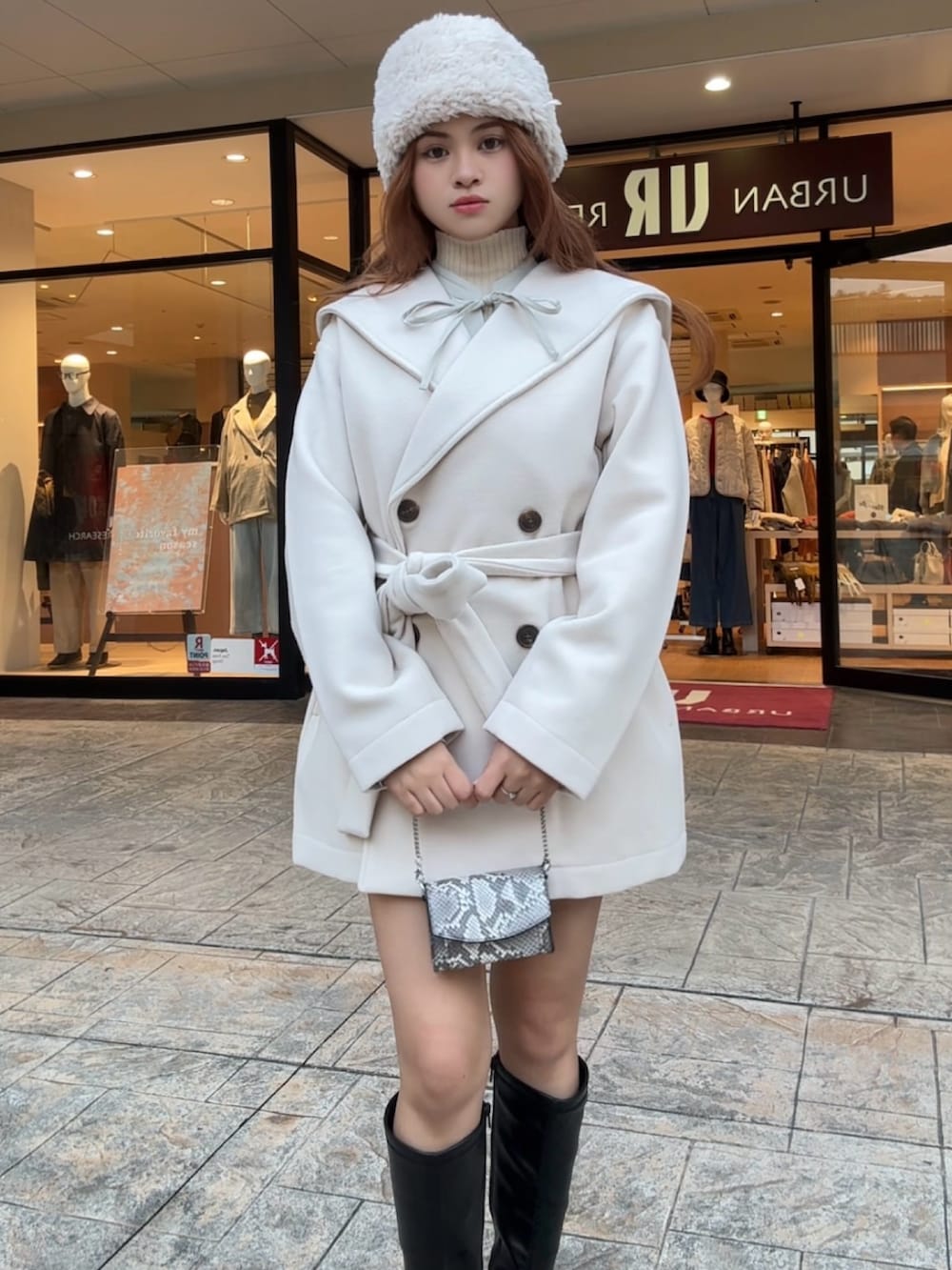 ホワイト系のニット/セーター、ブラック系のブーツ、その他のショルダーバッグを着用したレディースの秋コーディネートの4枚目の写真