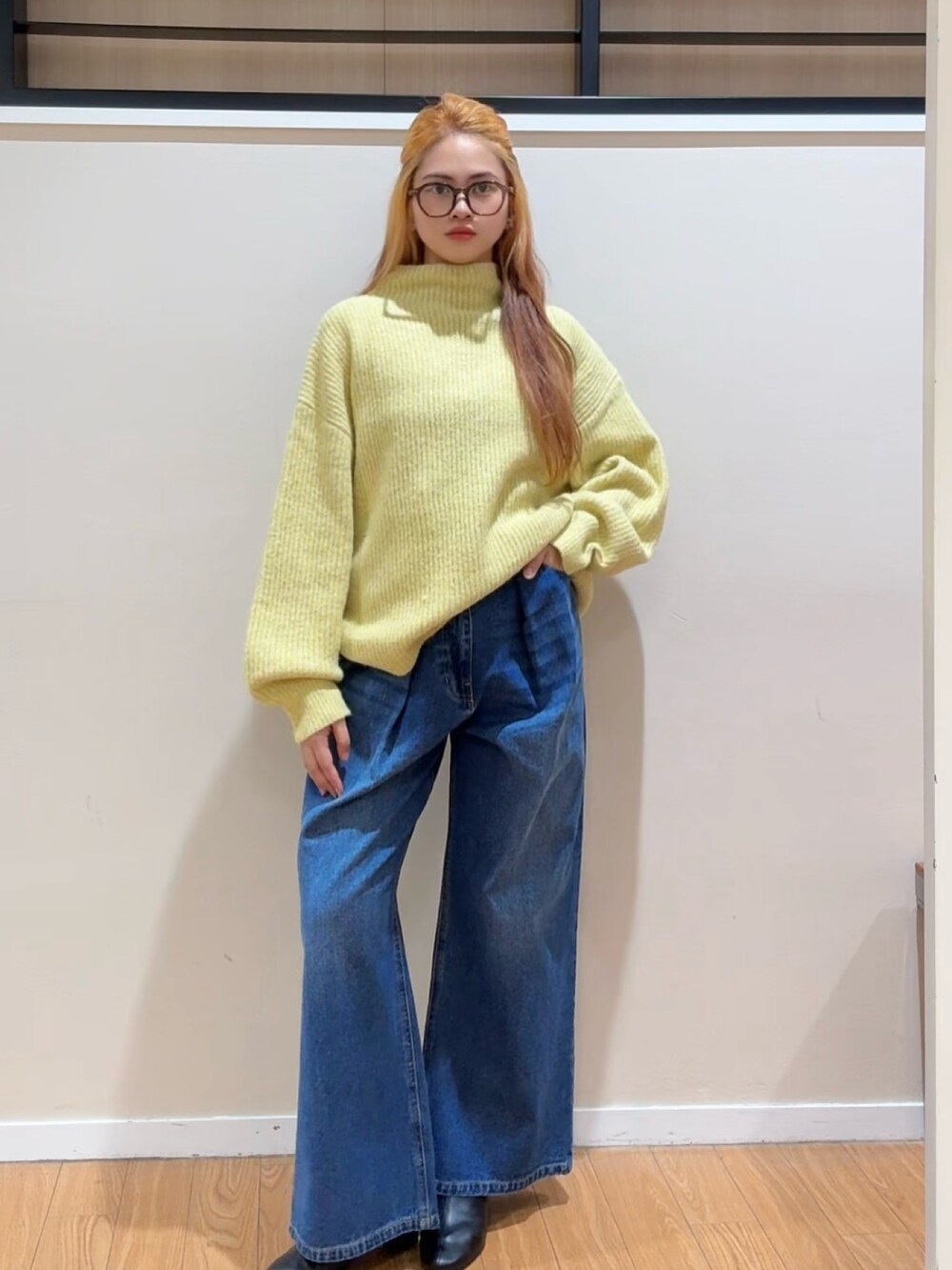 イエロー系のニット/セーター、ブルー系のデニムパンツ、ブラック系のブーツを着用したレディースの冬コーディネートの3枚目の写真