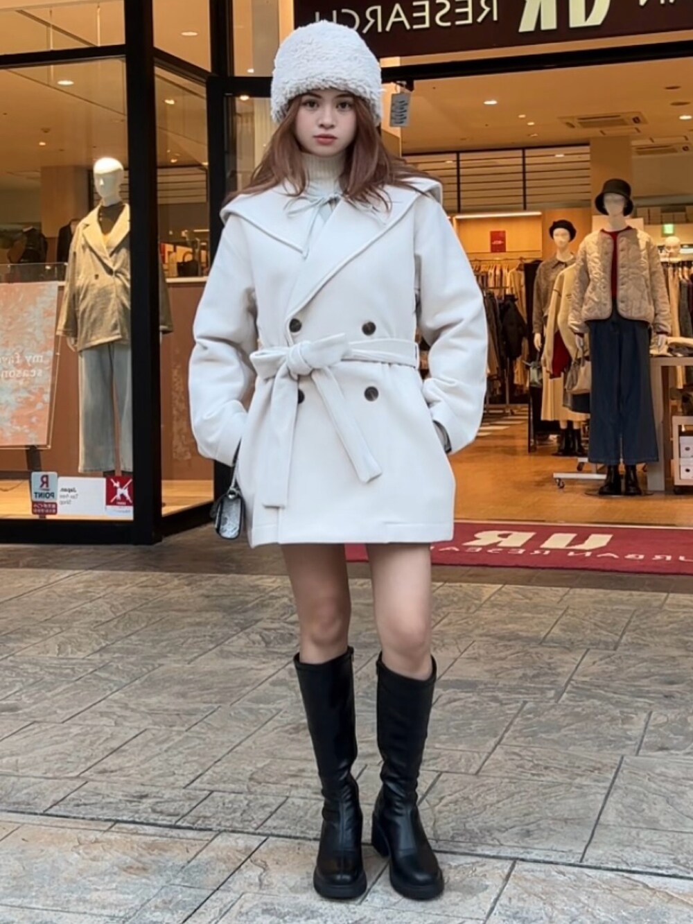 ホワイト系のニット/セーター、ブラック系のブーツ、その他のショルダーバッグを着用したレディースの秋コーディネートの5枚目の写真