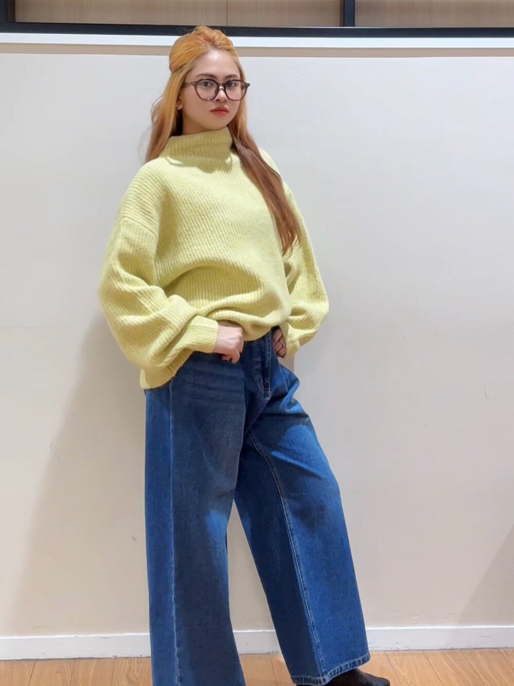 イエロー系のニット/セーター、ブルー系のデニムパンツ、ブラック系のブーツを着用したレディースの冬コーディネートの4枚目の写真