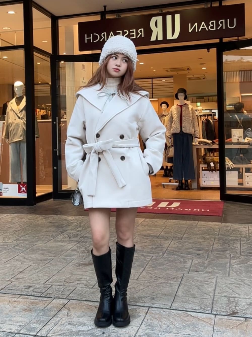 ホワイト系のニット/セーター、ブラック系のブーツ、その他のショルダーバッグを着用したレディースの秋コーディネートの6枚目の写真