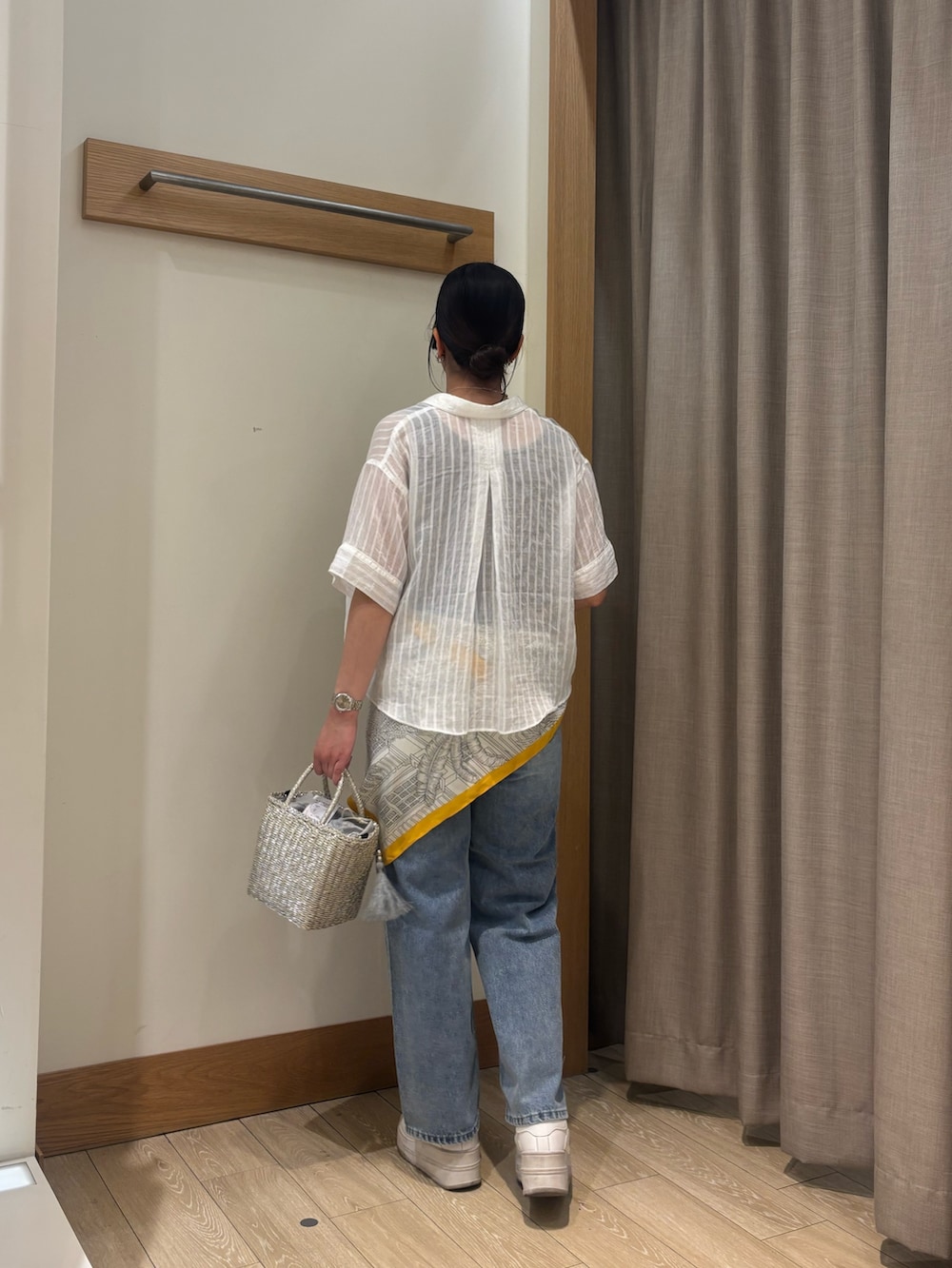 ホワイト系のシャツ/ブラウス、ブラウン系のタンクトップ、ブルー系のデニムパンツを着用したレディースの春コーディネートの2枚目の写真