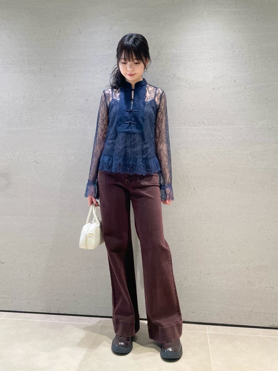 ブラウン系のデニムパンツ、ホワイト系のボストンバッグを着用したレディースの秋コーディネートの3枚目の写真