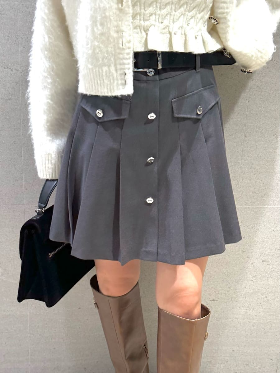 イエロー系のブーツ、ホワイト系のアンサンブル、ブラック系のハンドバッグを着用したレディースの秋コーディネートの6枚目の写真