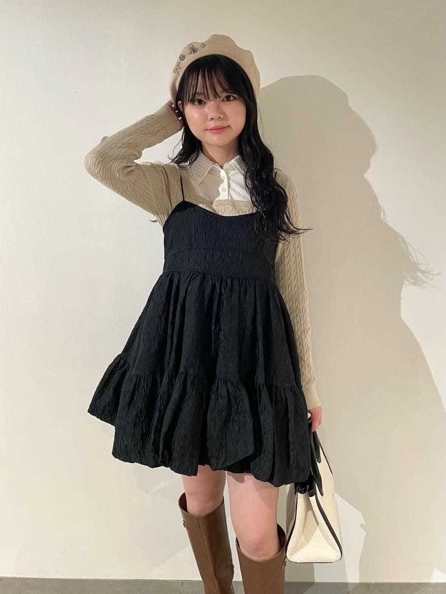 ホワイト系のトートバッグ、イエロー系のブーツ、ブラック系のワンピースを着用したレディースの冬コーディネートの5枚目の写真