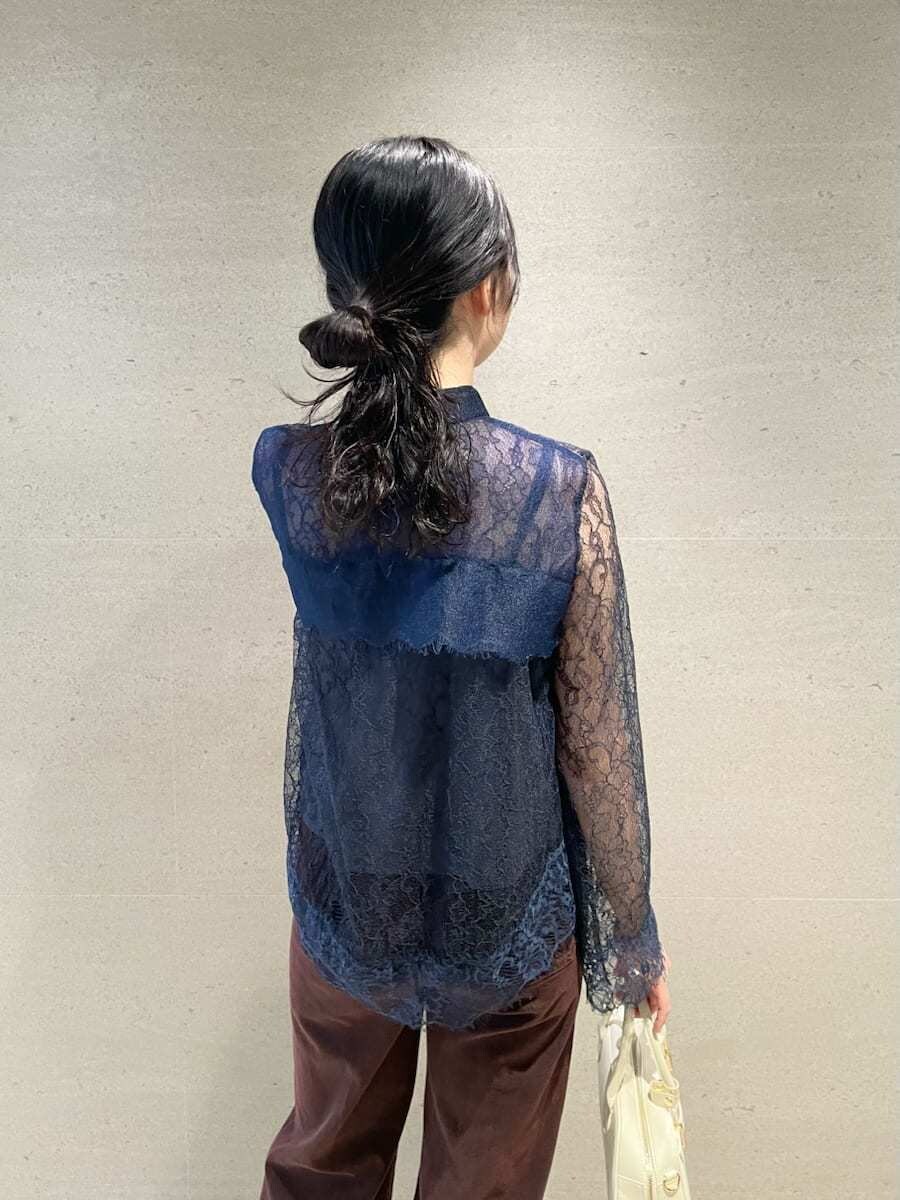 ブラウン系のデニムパンツ、ホワイト系のボストンバッグを着用したレディースの秋コーディネートの4枚目の写真