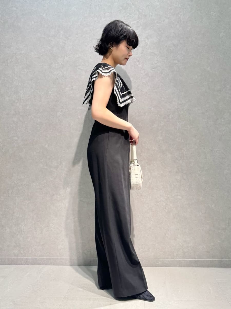 ホワイト系のハンドバッグ、ブルー系のパンプス、ブラウン系のイヤリングを着用したレディースの秋コーディネートの2枚目の写真