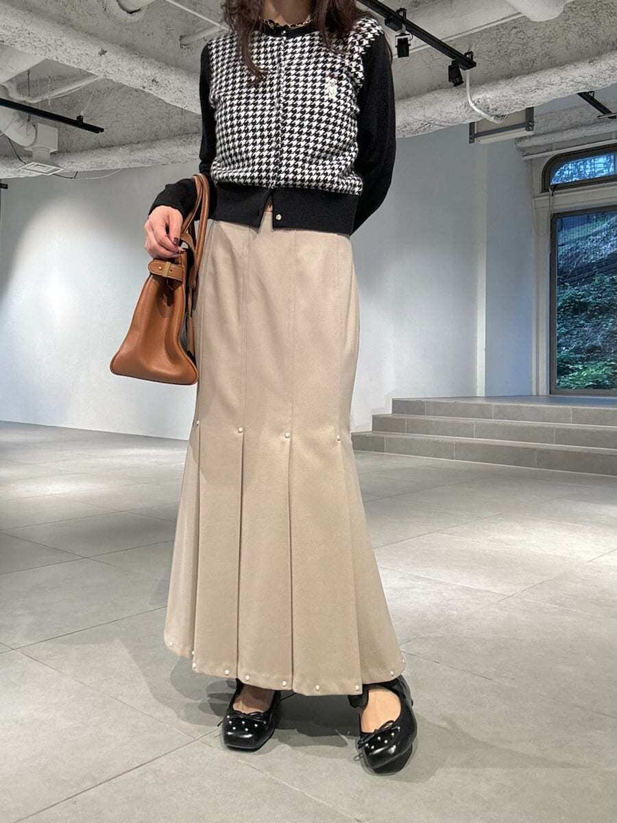 その他のカーディガン/ボレロ、イエロー系のトートバッグ、ブラック系のパンプスを着用したレディースの冬コーディネートの4枚目の写真