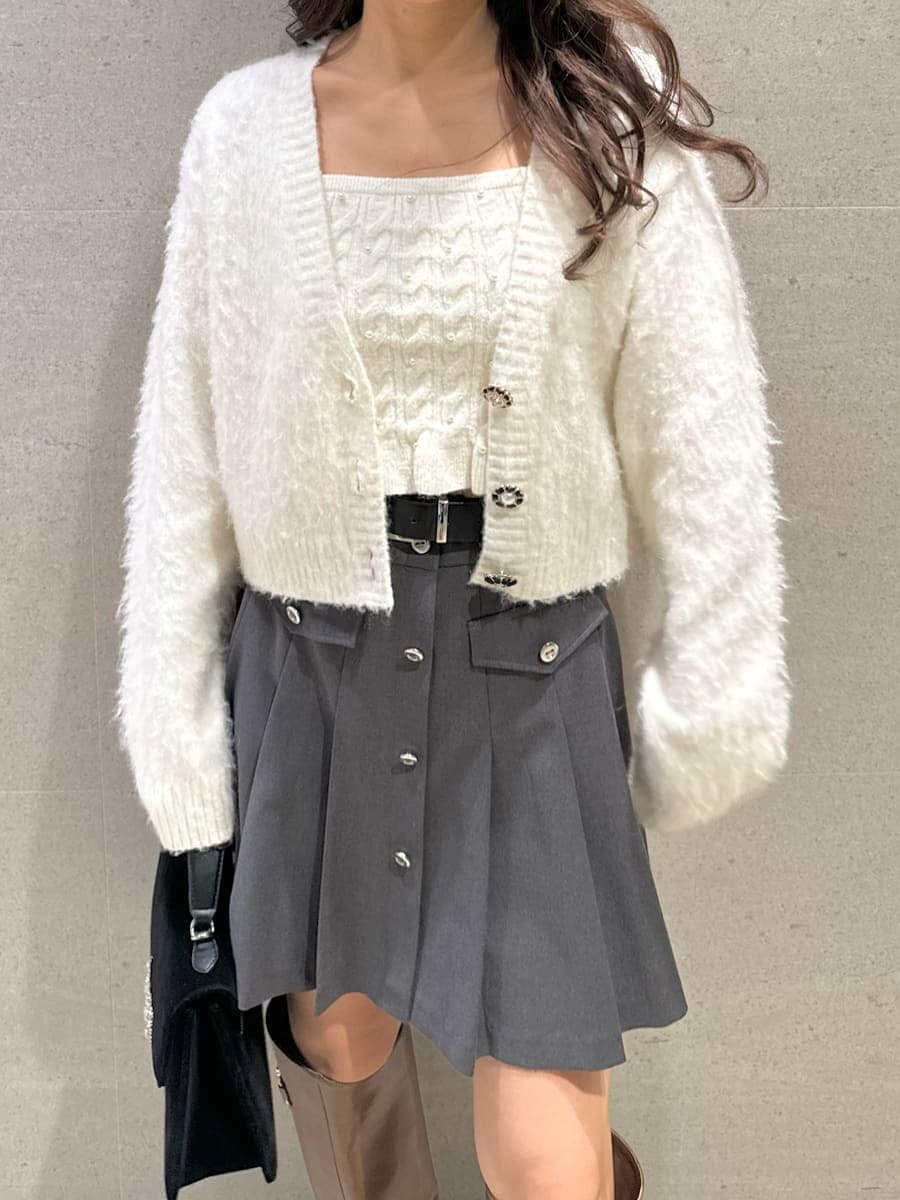 イエロー系のブーツ、ホワイト系のアンサンブル、ブラック系のハンドバッグを着用したレディースの秋コーディネートの4枚目の写真