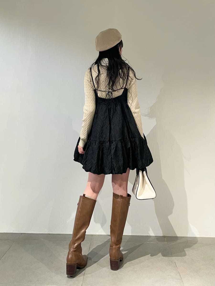 ホワイト系のトートバッグ、イエロー系のブーツ、ブラック系のワンピースを着用したレディースの冬コーディネートの4枚目の写真