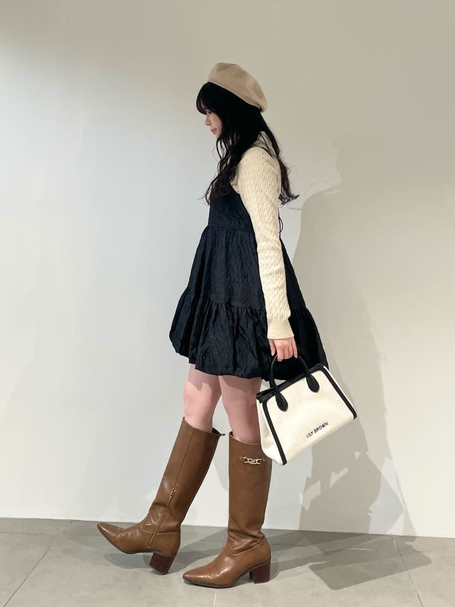 ホワイト系のトートバッグ、イエロー系のブーツ、ブラック系のワンピースを着用したレディースの冬コーディネートの3枚目の写真