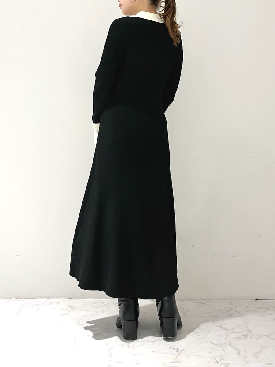 ブラック系のワンピース、ブラック系のブーツ、ホワイト系のハンドバッグを着用したレディースの秋コーディネートの5枚目の写真