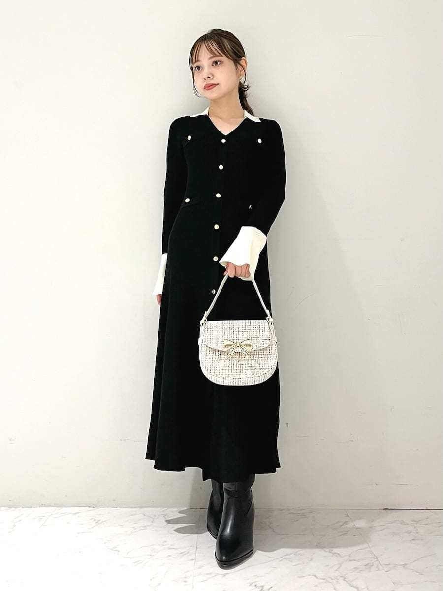 ブラック系のワンピース、ブラック系のブーツ、ホワイト系のハンドバッグを着用したレディースの秋コーディネートの2枚目の写真