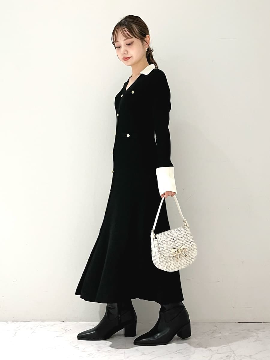 ブラック系のワンピース、ブラック系のブーツ、ホワイト系のハンドバッグを着用したレディースの秋コーディネートの4枚目の写真