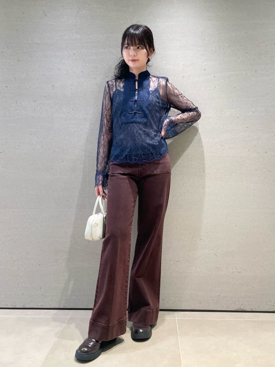 ブラウン系のデニムパンツ、ホワイト系のボストンバッグを着用したレディースの秋コーディネートの2枚目の写真