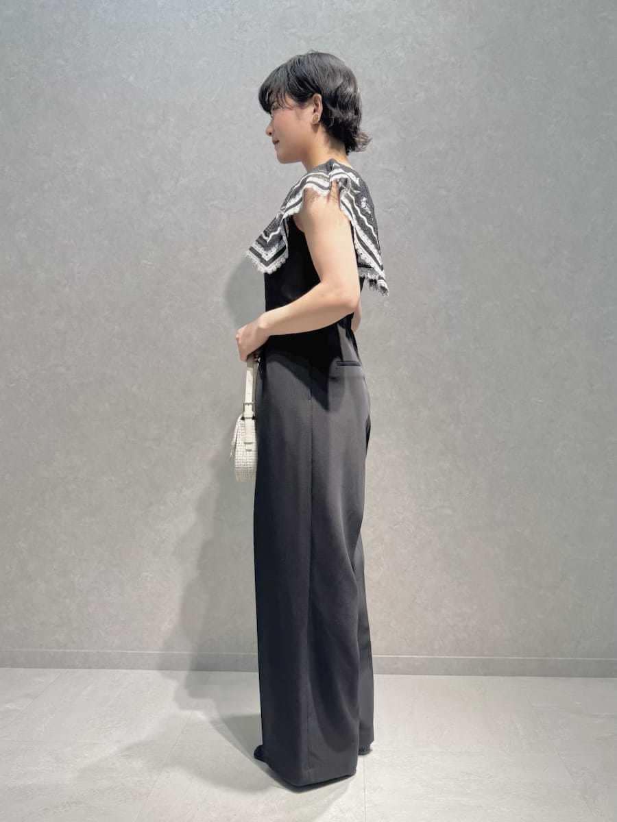 ホワイト系のハンドバッグ、ブルー系のパンプス、ブラウン系のイヤリングを着用したレディースの秋コーディネートの3枚目の写真