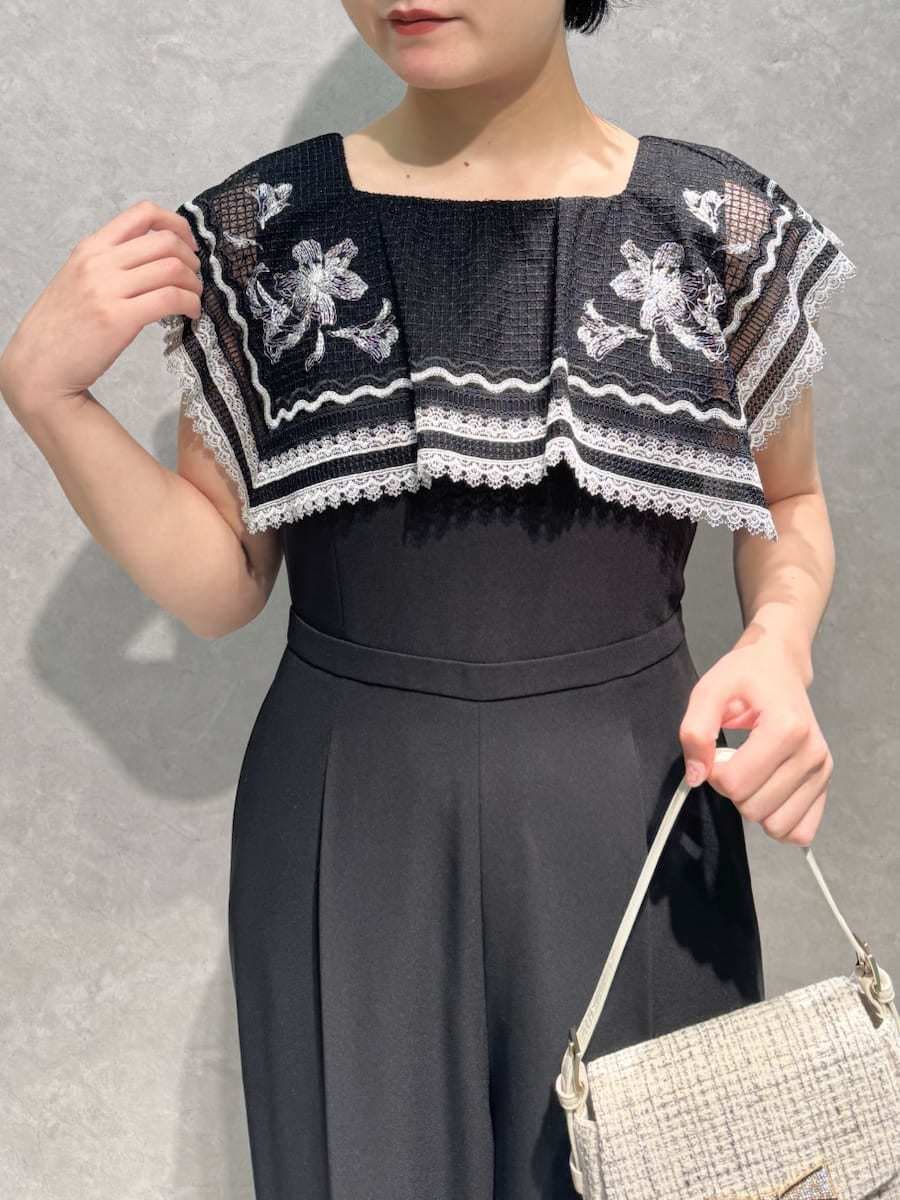 ホワイト系のハンドバッグ、ブルー系のパンプス、ブラウン系のイヤリングを着用したレディースの秋コーディネートの5枚目の写真