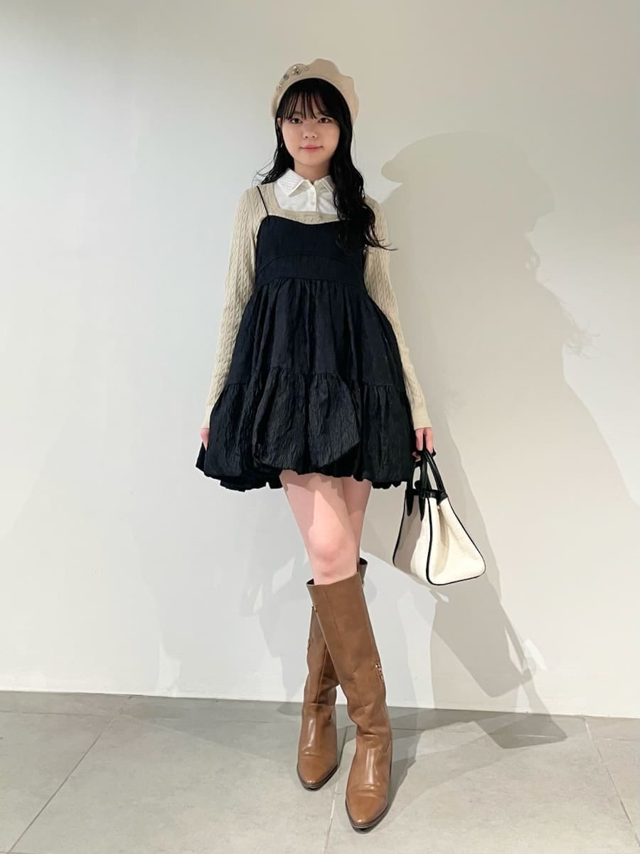 ホワイト系のトートバッグ、イエロー系のブーツ、ブラック系のワンピースを着用したレディースの冬コーディネートの2枚目の写真