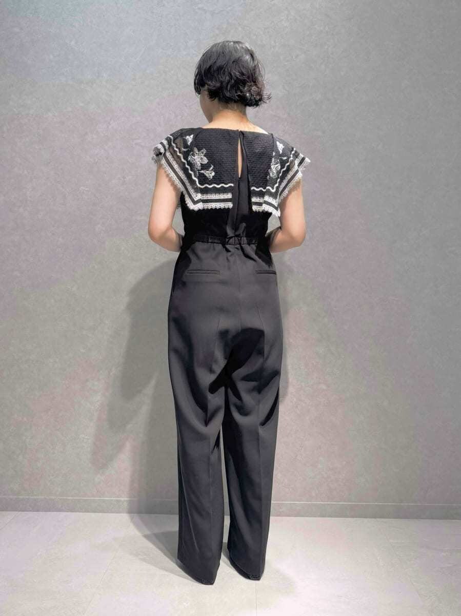 ホワイト系のハンドバッグ、ブルー系のパンプス、ブラウン系のイヤリングを着用したレディースの秋コーディネートの4枚目の写真