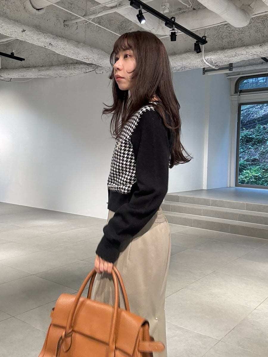 その他のカーディガン/ボレロ、イエロー系のトートバッグ、ブラック系のパンプスを着用したレディースの冬コーディネートの3枚目の写真