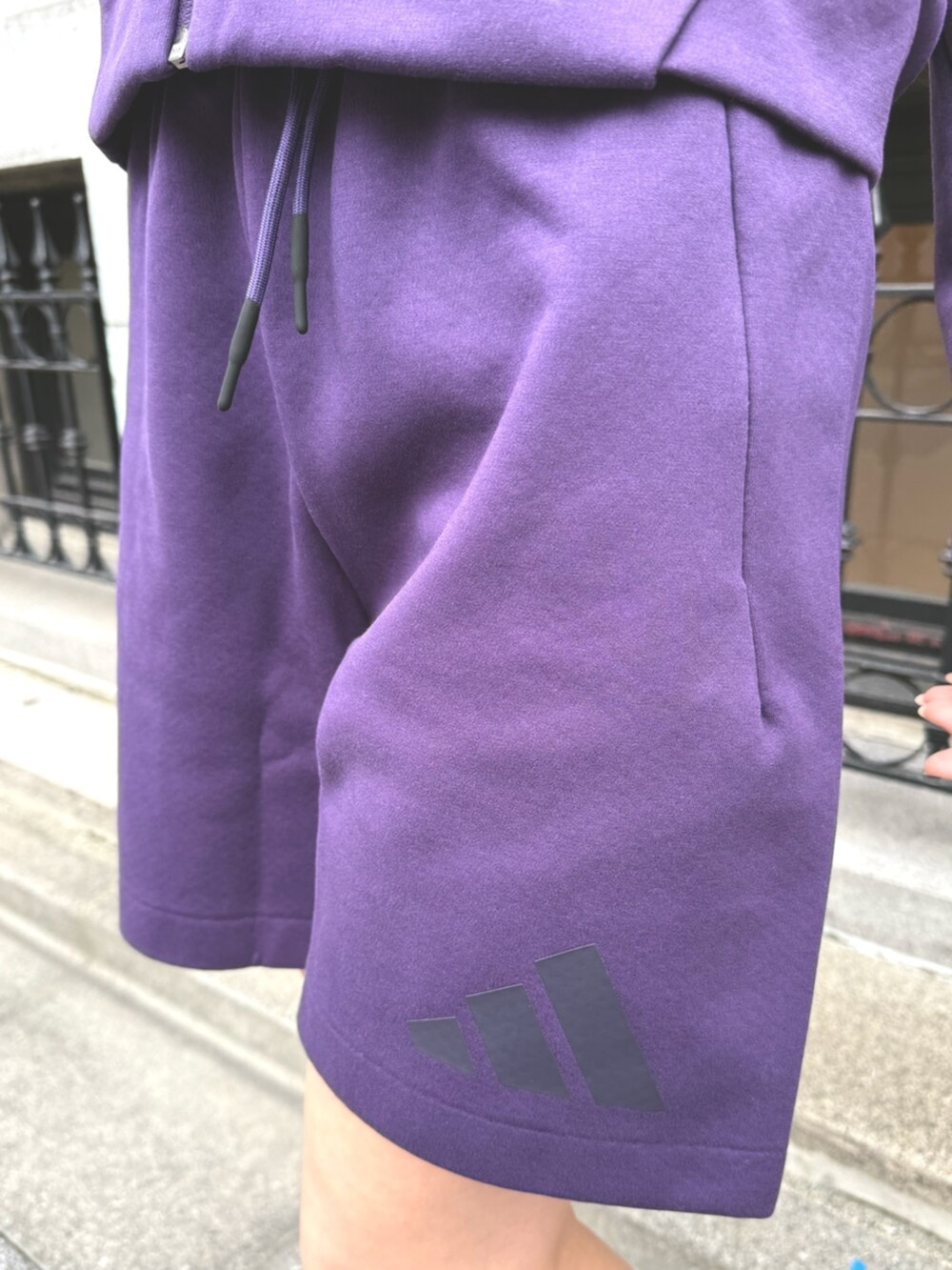 パープル系のパーカー、パープル系のその他パンツ、ホワイト系のスニーカーを着用したレディースの秋コーディネートの3枚目の写真