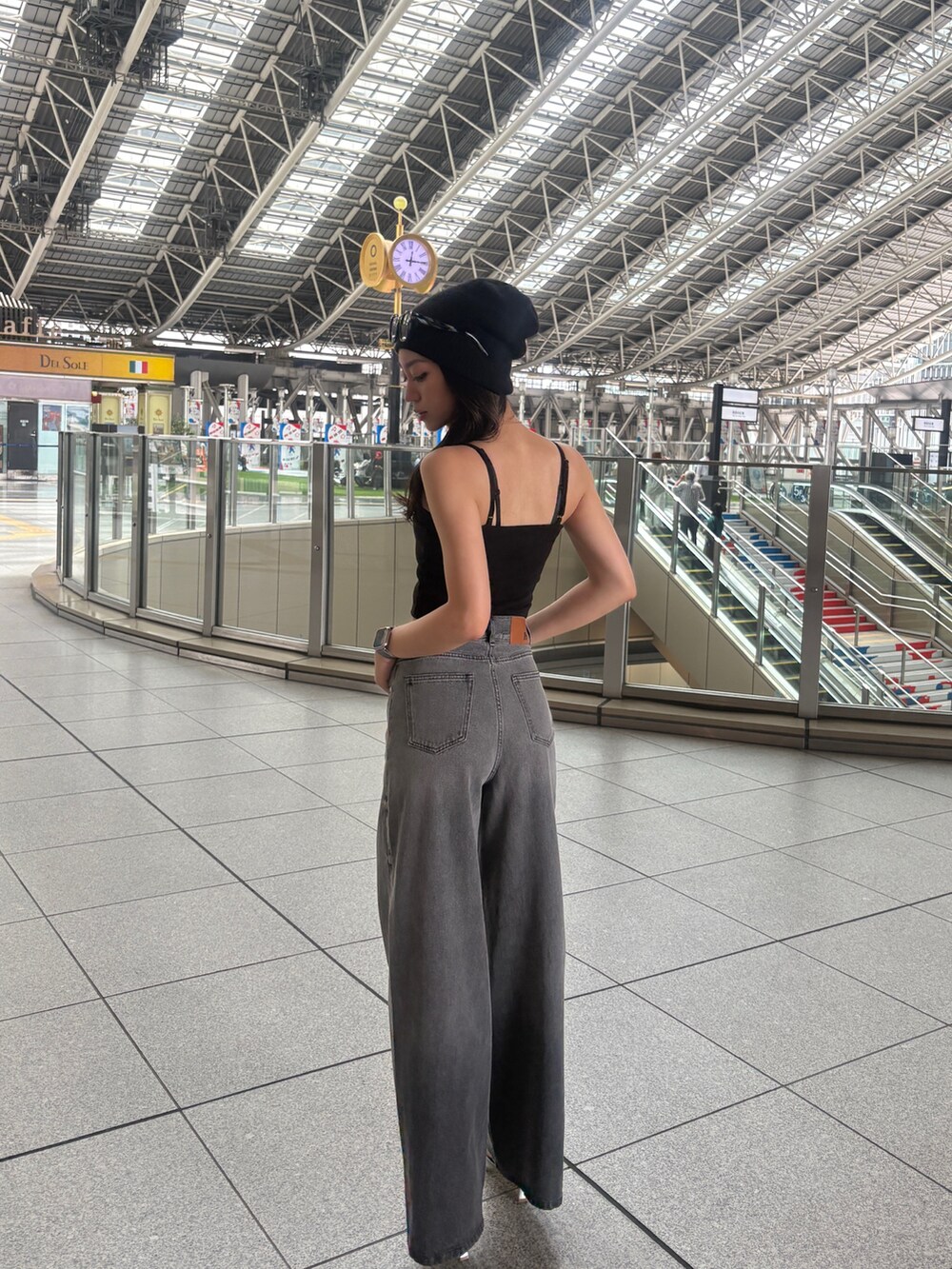 ブラック系のデニムパンツを着用したレディースの春コーディネートの2枚目の写真