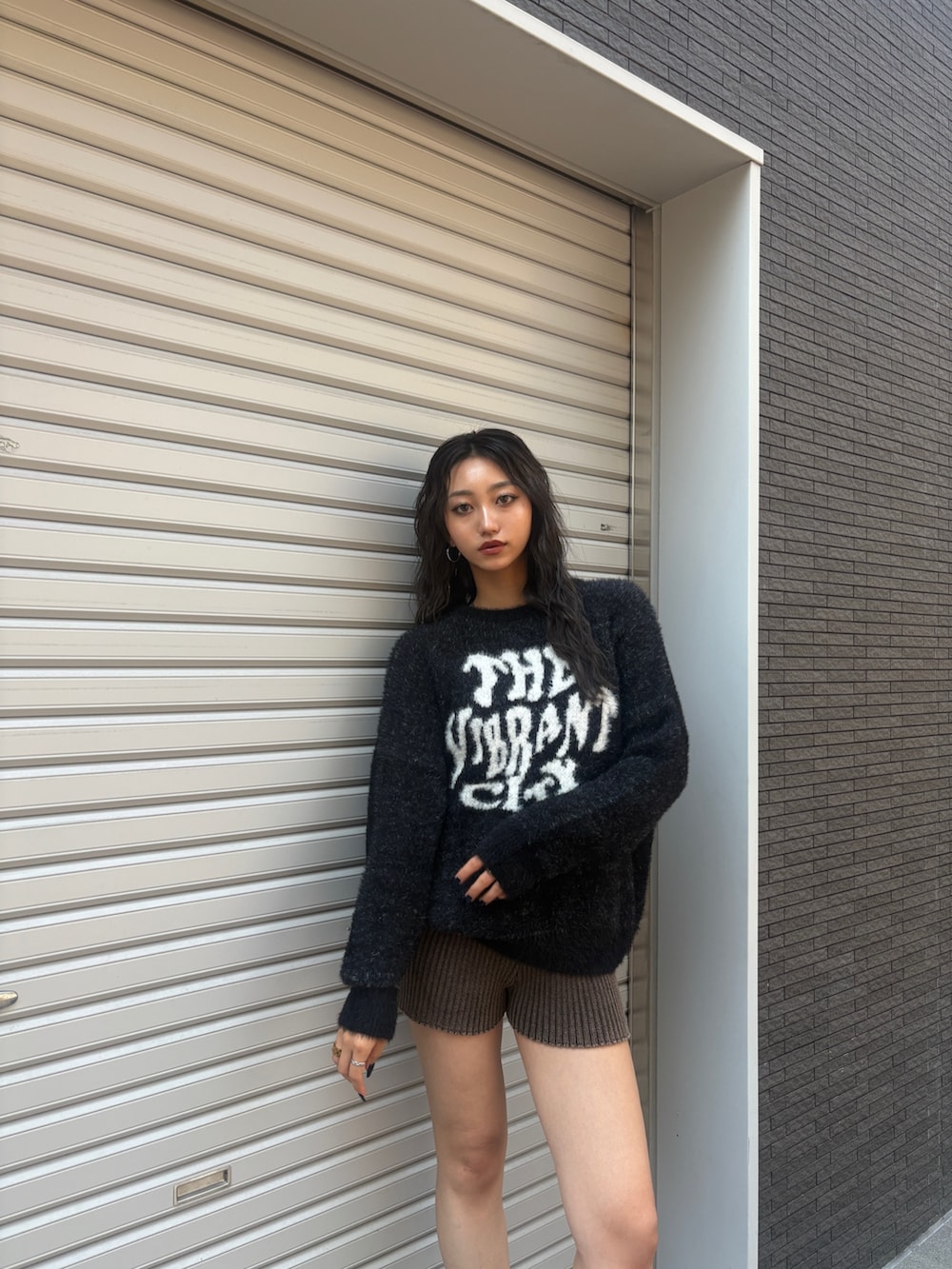 ブラック系のニット/セーター、ブラウン系のその他パンツ、ブラック系のブーツを着用したレディースの秋コーディネートの4枚目の写真