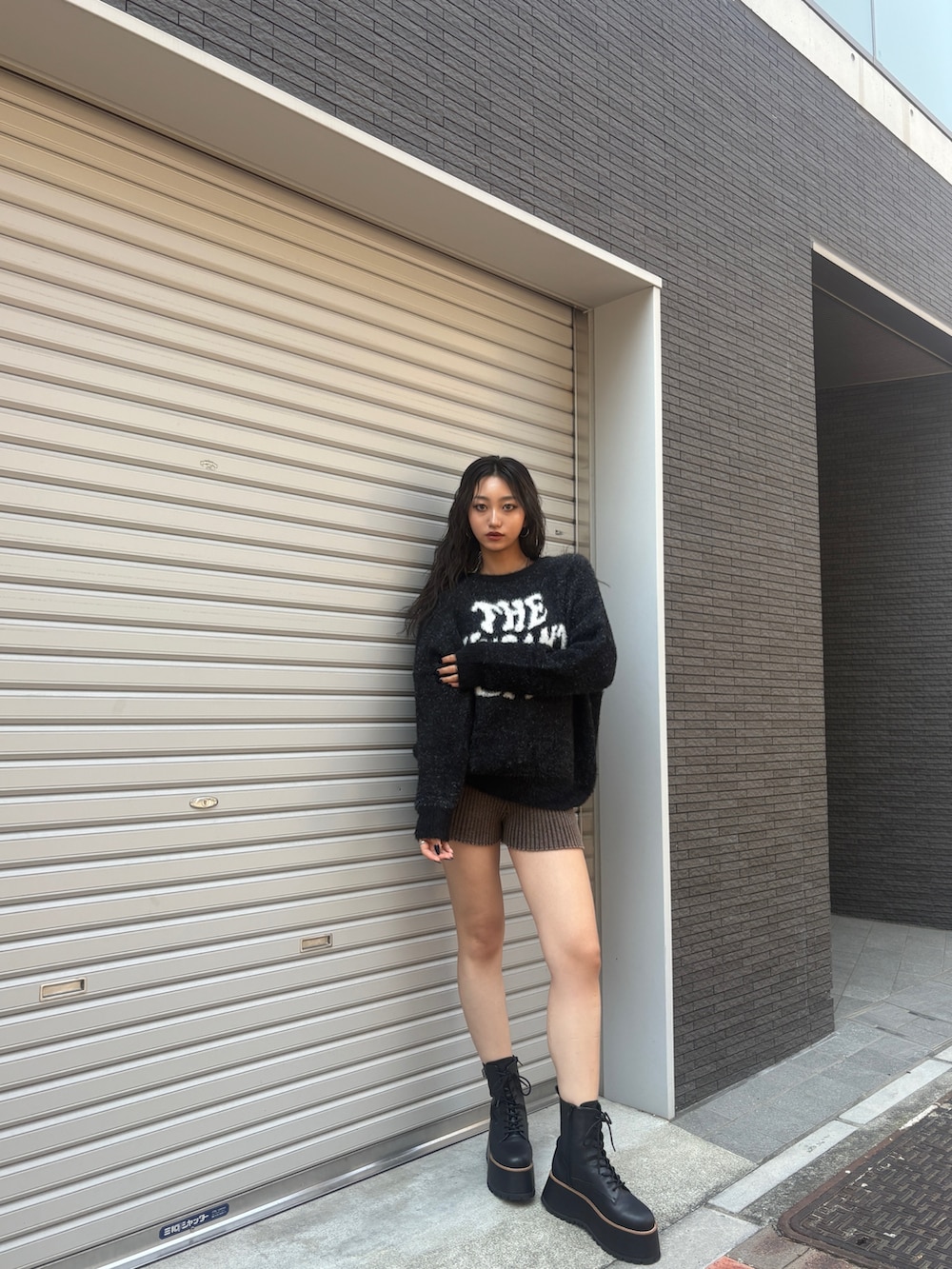 ブラック系のニット/セーター、ブラウン系のその他パンツ、ブラック系のブーツを着用したレディースの秋コーディネートの2枚目の写真