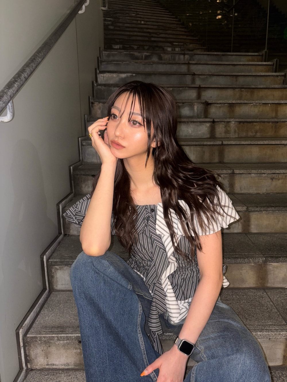 ブラック系のシャツ/ブラウス、ブルー系のデニムパンツを着用したレディースの春コーディネートの2枚目の写真