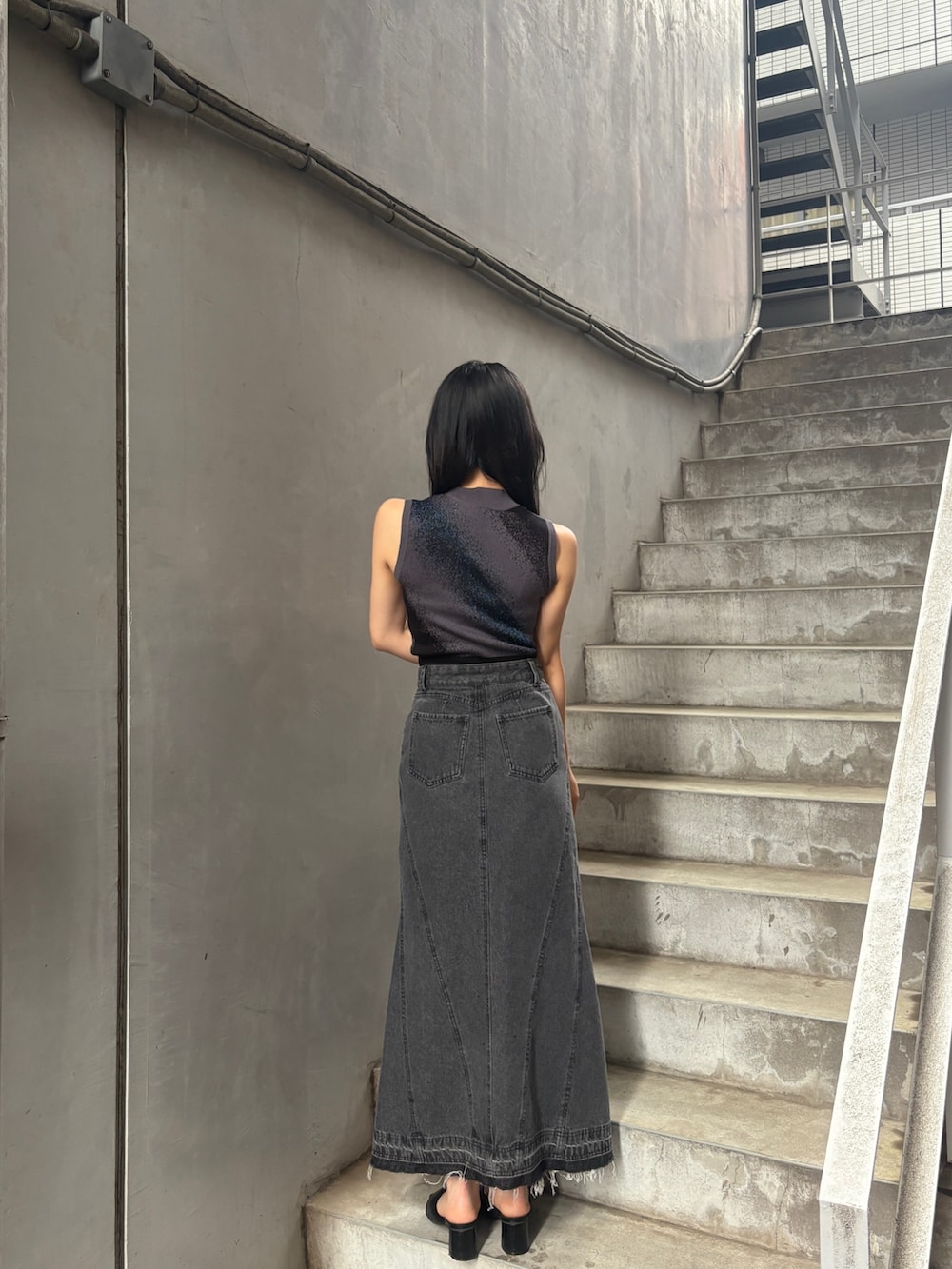 ブラック系のタンクトップ、ブラック系のデニムスカートを着用したレディースの夏コーディネートの4枚目の写真