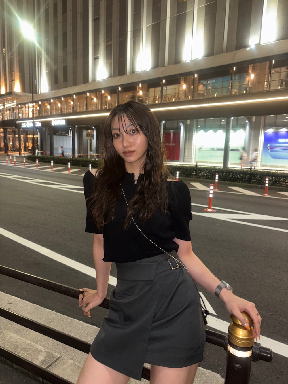 ブラック系のニット/セーター、ブラック系のショルダーバッグ、グレー系のスカートを着用したレディースの春コーディネートの3枚目の写真