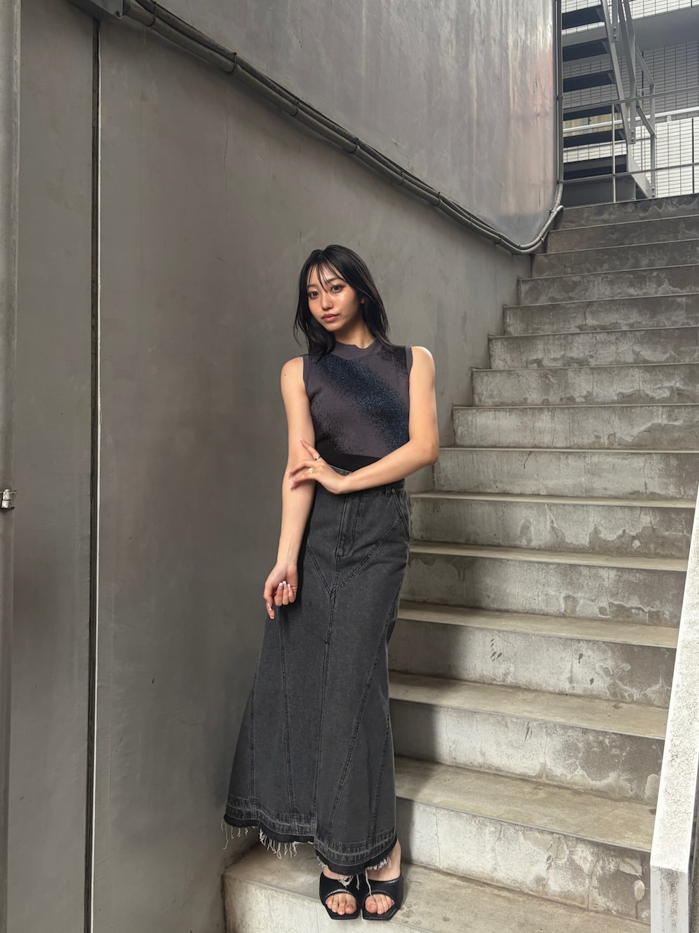 ブラック系のタンクトップ、ブラック系のデニムスカートを着用したレディースの夏コーディネートの3枚目の写真