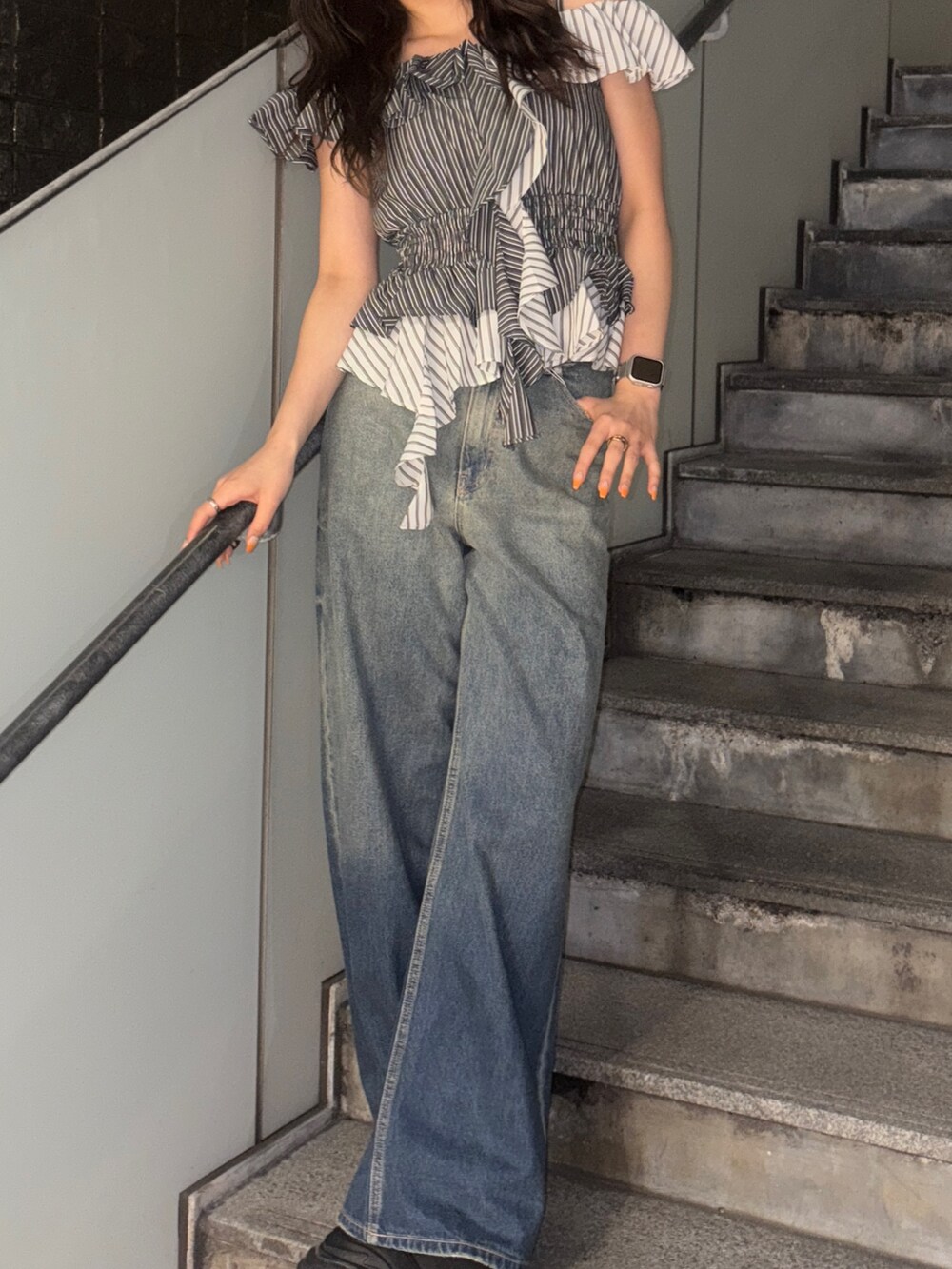 ブラック系のシャツ/ブラウス、ブルー系のデニムパンツを着用したレディースの春コーディネートの3枚目の写真