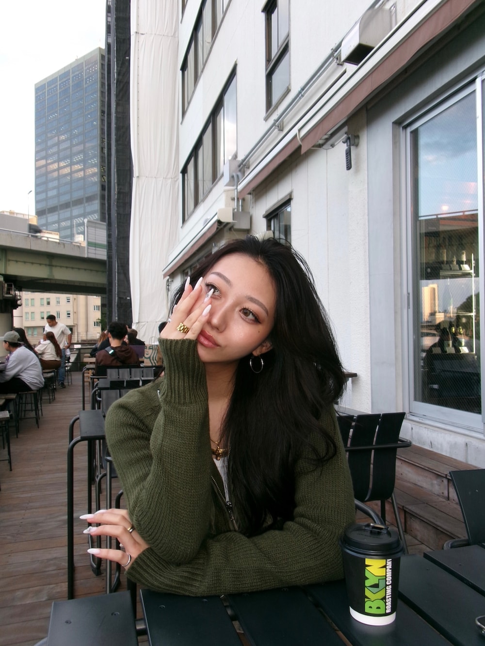 グリーン系のニット/セーターを着用したレディースの秋コーディネートの2枚目の写真