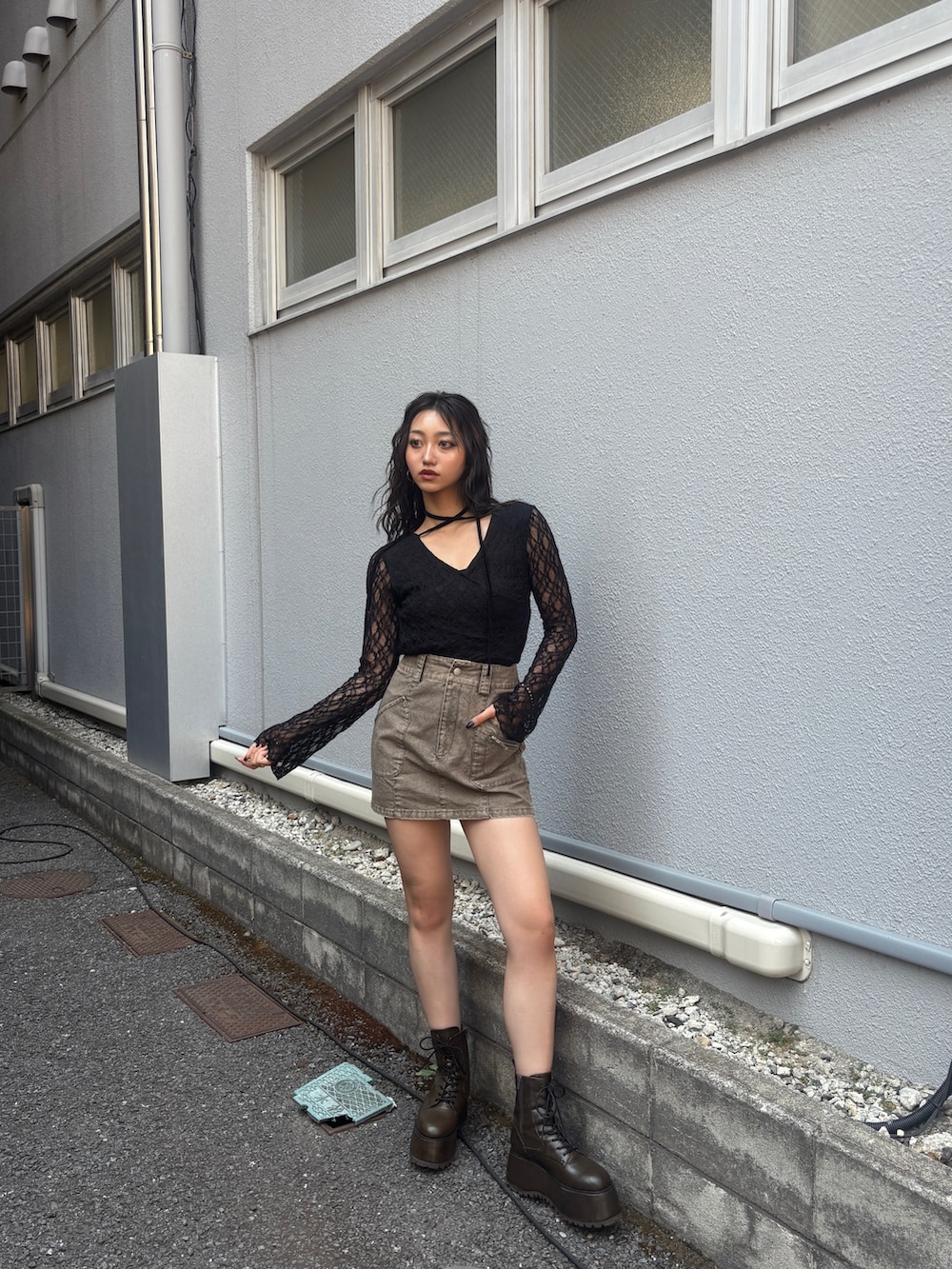 ブラック系のTシャツ/カットソー、グレー系のスカート、ブラウン系のブーツを着用したレディースの秋コーディネートの2枚目の写真