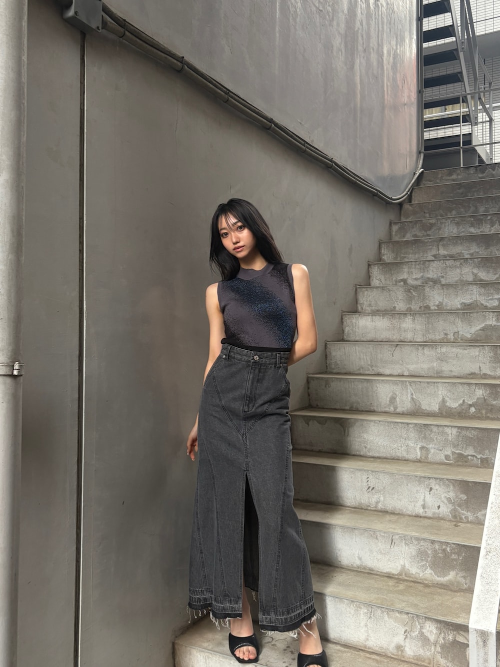 ブラック系のタンクトップ、ブラック系のデニムスカートを着用したレディースの夏コーディネートの2枚目の写真