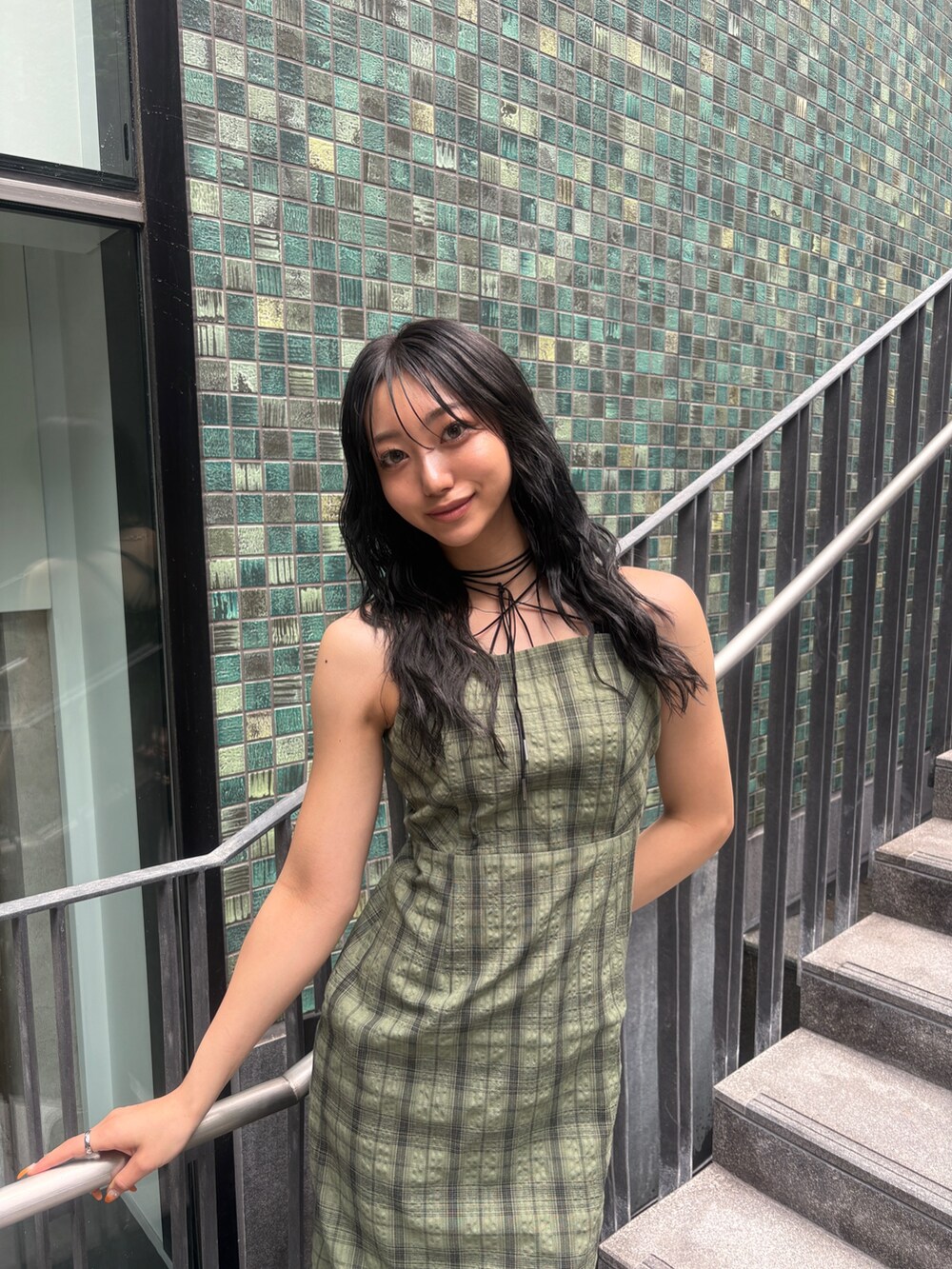 グリーン系のワンピースを着用したレディースの夏コーディネートの2枚目の写真