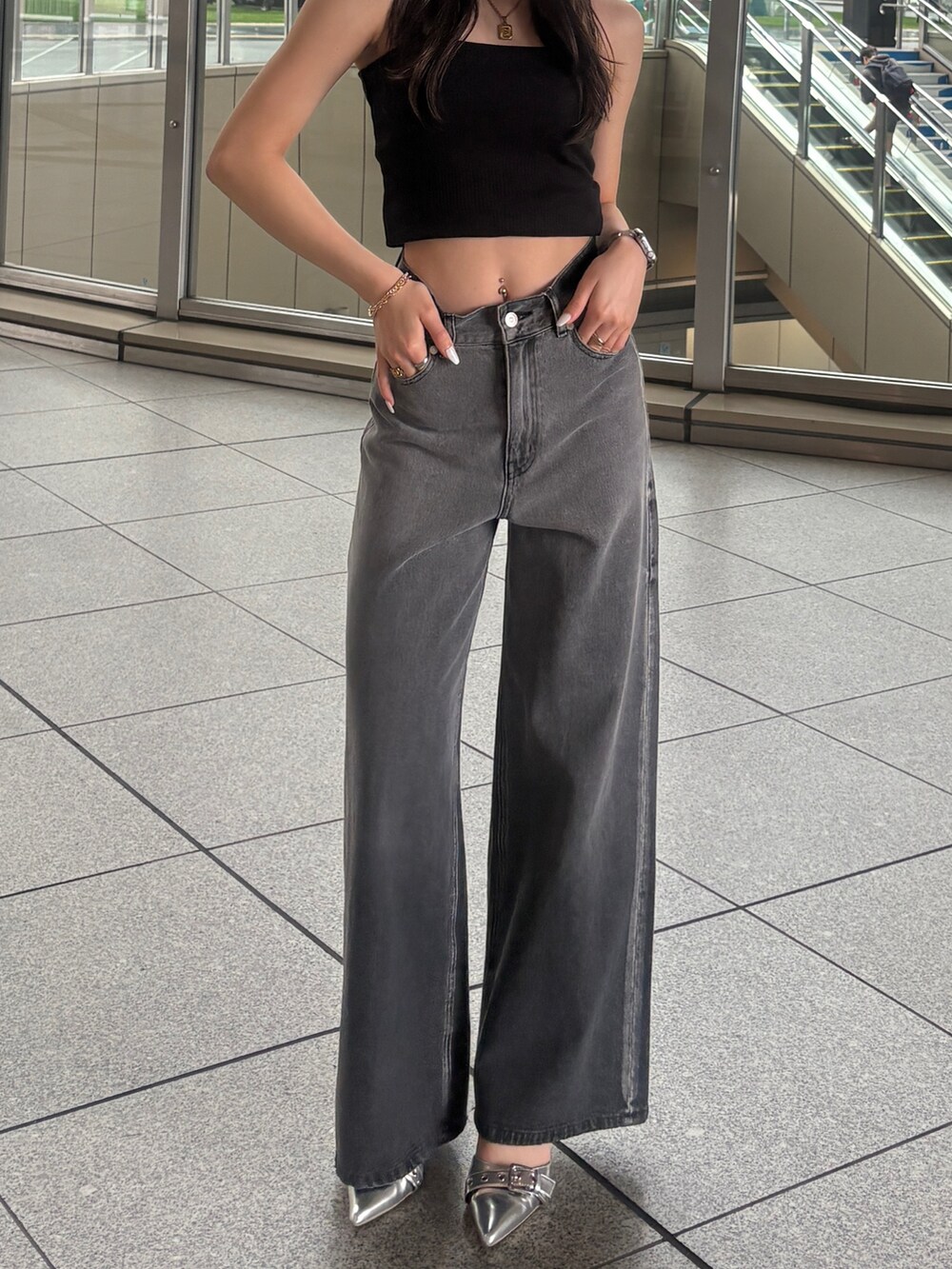 ブラック系のデニムパンツを着用したレディースの春コーディネートの3枚目の写真