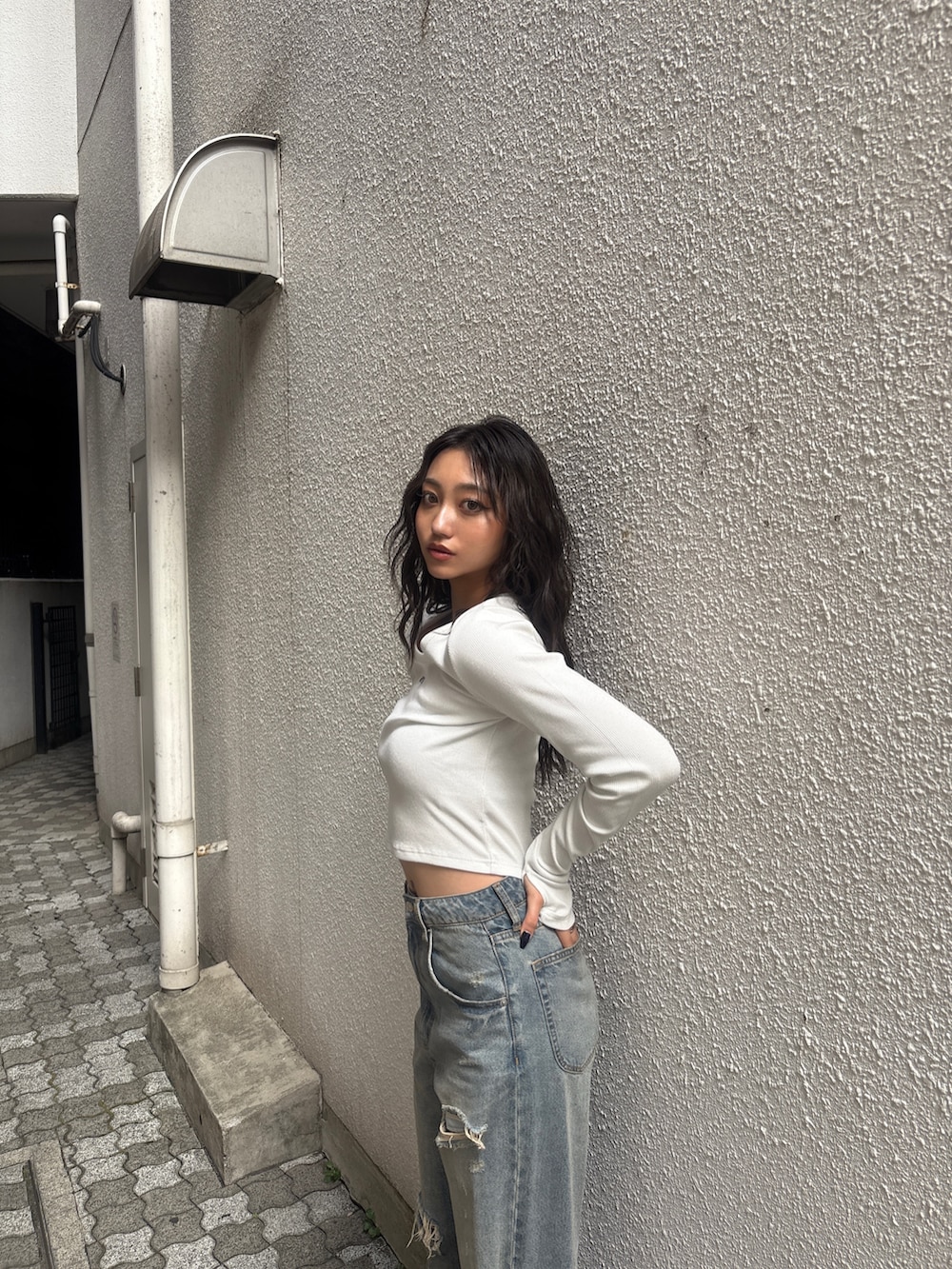 ブルー系のデニムパンツ、イエロー系のローファー、ホワイト系のTシャツ/カットソーを着用したレディースの秋コーディネートの3枚目の写真