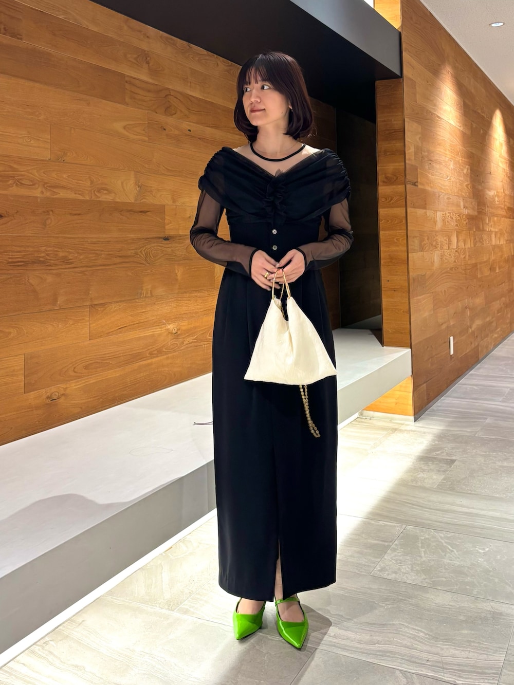ブラック系のドレス、グリーン系のパンプスを着用したレディースの冬コーディネートの2枚目の写真