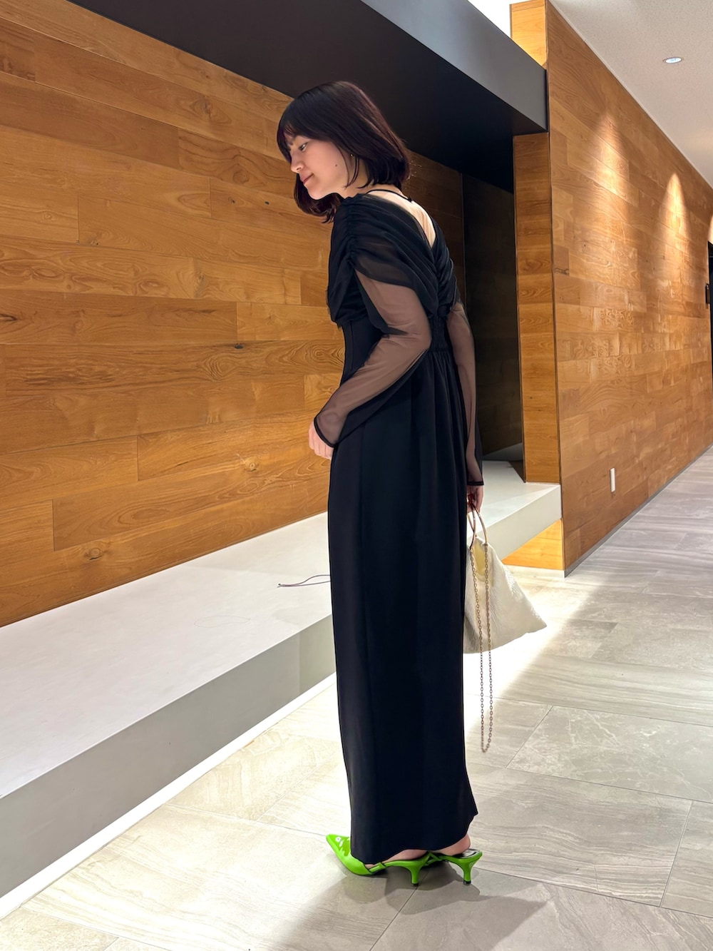 ブラック系のドレス、グリーン系のパンプスを着用したレディースの冬コーディネートの3枚目の写真