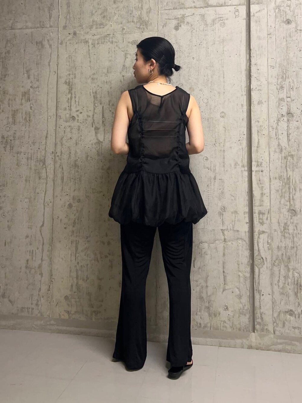 ブラック系のチュニック、ブラック系のその他パンツ、ホワイト系のネックレスを着用したレディースの夏コーディネートの4枚目の写真