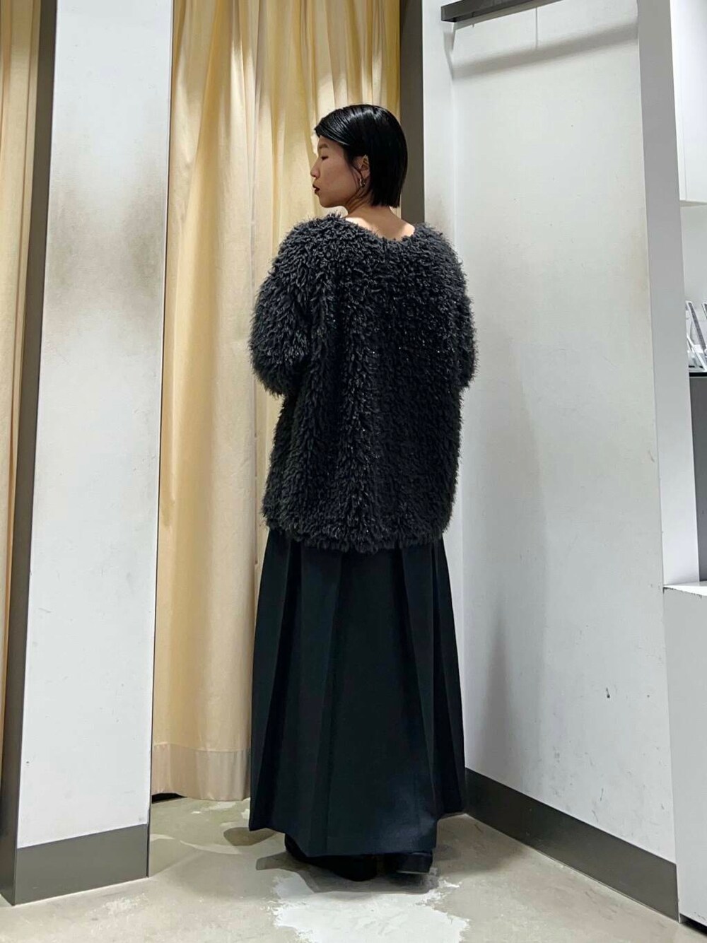 グレー系のワンピース、ブラック系のショルダーバッグ、グレー系のニット/セーターを着用したレディースの冬コーディネートの4枚目の写真